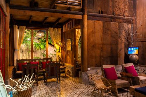 a living room with chairs and tables and a television at De Yang House Sa Pa in Sapa