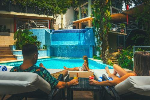 a group of people sitting in chairs by a swimming pool at Jungle Vista Boutique Hotel in Manuel Antonio
