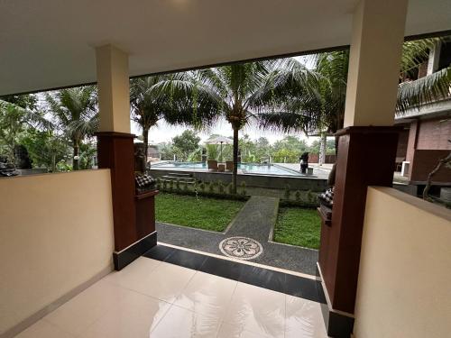 a room with a view of a courtyard with palm trees at Brata Cottage Ubud in Ubud
