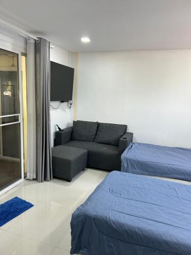 a living room with a couch and a tv at Nongnuchs Homestay Two Single Beds in San Sai