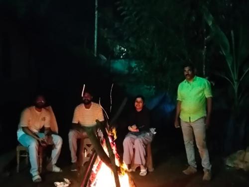 a group of people standing around a fire at Riya Home Stay Munnar in Anaviratty