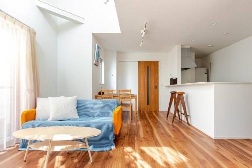 a living room with a blue couch and a table at Chigasaki vacation house in Chigasaki
