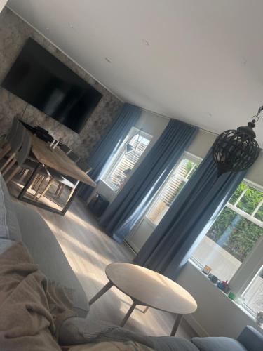 a living room with blue curtains and a chair at Solbacken 59 in Landvetter