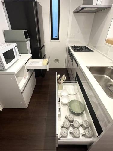 a small kitchen with a sink and a microwave at Osaka KyoSai-A 栖晚 in Osaka
