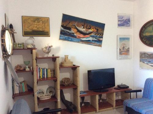 a living room with a tv and bookshelves at Favignana Vacanze in Favignana