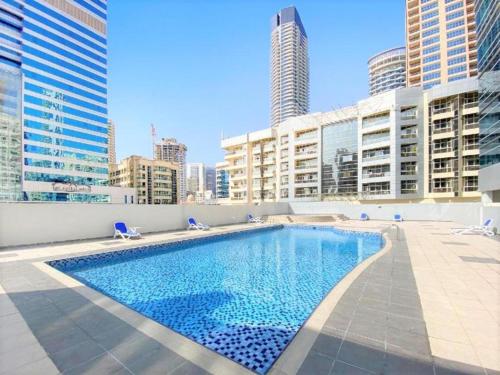 a swimming pool on the roof of a building with tall buildings at Royal Manor- Marina Diamond 2 in Dubai