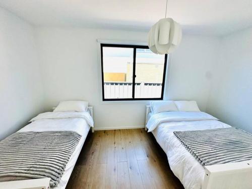 カウズにあるModern Island Escapeの窓のある部屋にベッドが2つある
