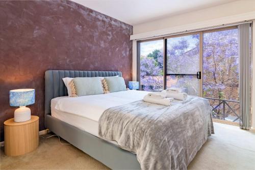 a bedroom with a bed and a large window at 2BR Urban Nest Cosy & Central - Free Parking in Adelaide