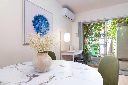 a room with a table with a vase on it at 2BR Urban Nest Cosy & Central - Free Parking in Adelaide