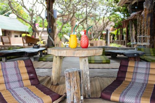 two colorful vases sitting on a table with two chairs at Lanta Riviera Beach Resort in Ko Lanta