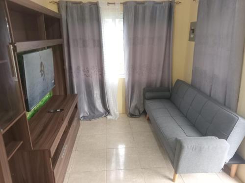 a living room with a couch and a flat screen tv at Villa D'Vene in Belle Air Summit