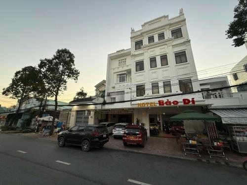 a building with cars parked in front of a store at Bảo Di Sóc Trăng Hotel in Soc Trang