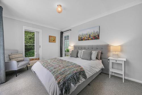 奥兰治Meadowbrook MTB Lodge Orange - Rip on the trails, sip on the wine!的带一张大床和一把椅子的卧室