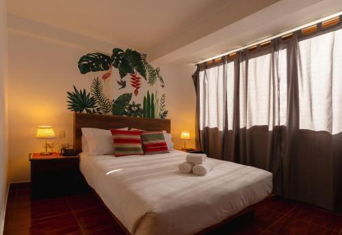a bedroom with a bed with a teddy bear on it at Susanna Inn Machupicchu in Machu Picchu