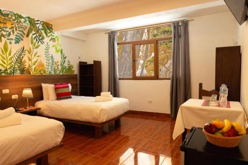 a hotel room with two beds and a window at Susanna Inn Machupicchu in Machu Picchu