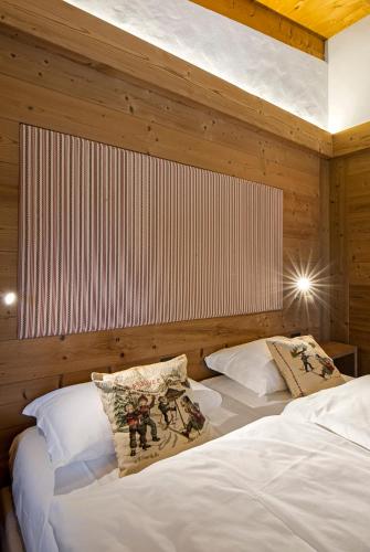 two beds in a room with wooden walls at Baita Fraina in Cortina dʼAmpezzo