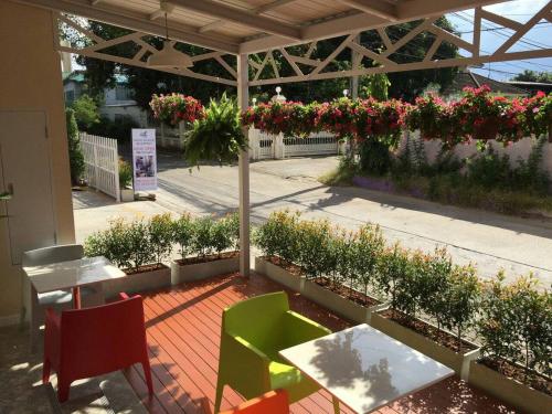 a patio with a table and chairs and flowers at The Garden Living in Bangkok