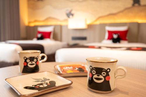 two coffee cups sitting on a table in a hotel room at KAMENOI HOTEL Aso in Aso
