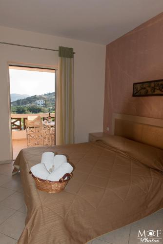 a bedroom with a bed with a chair and a balcony at Hotel Marilen in Alinda