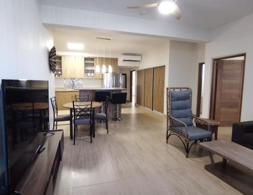 a living room with a table and chairs and a kitchen at Tumon Isa 16 Condo in Tamuning