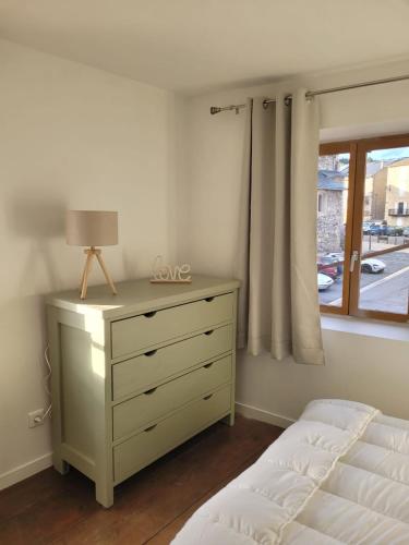 a bedroom with a bed and a dresser and a window at L'etoile Filante in Formiguères