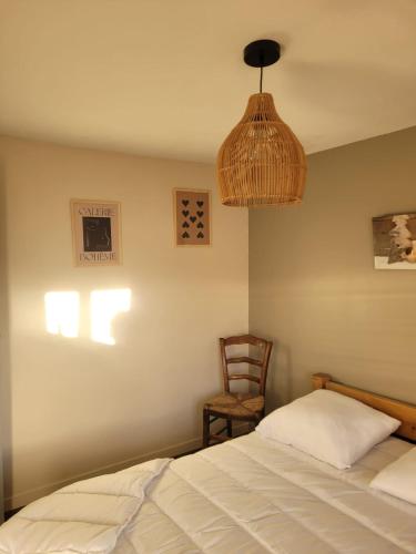 a bedroom with a bed and a chair and a lamp at L'etoile Filante in Formiguères