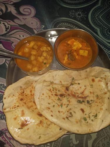 a plate of food with two bowls of soup and a tortilla at Katus in Gangtok