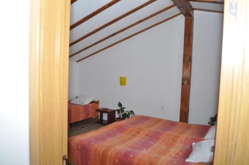 a bedroom with a bed and a wooden beam at Hotel Alpin - 91 Bansko in Bansko