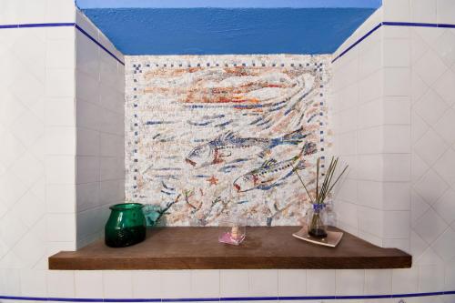a wall in a bathroom with a mosaic of fishes at Aquilamaior in Tragliata
