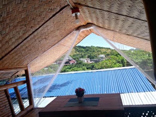 a view of a roof with a vase of flowers on a table at Charming seaview chalet with AC, kitchen, downtown in Coron