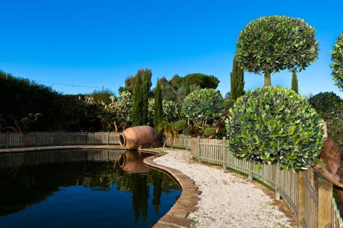 a pond in a garden with a fence and trees at Aquilamaior in Tragliata