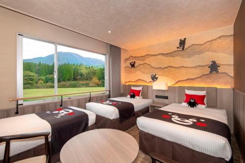 a room with three beds and a large window at KAMENOI HOTEL Aso in Aso