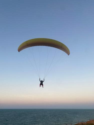 Una persona che vola un paracadute sull'oceano di Portal do Sol a Canoa Quebrada