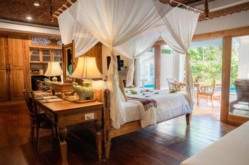 a bedroom with a bed and a desk and a table at Santhiya Koh Chang Resort in Ko Chang