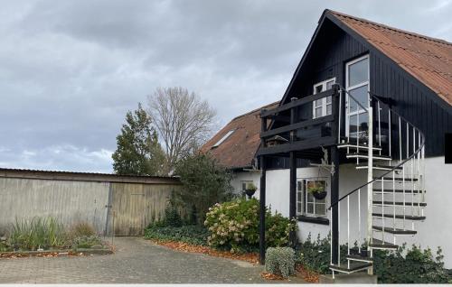 a black and white house with a black roof at Tante Jannis Sommerpension in Bogense