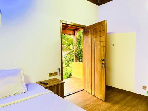 a bedroom with a bed and a open door at Angel Eco Resort, Cox Bazar in Dhoāpālong
