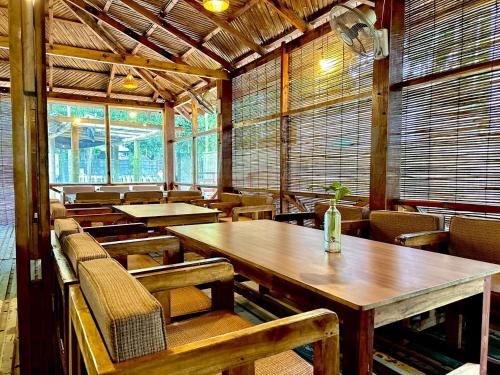 an empty restaurant with wooden tables and chairs at Angel Eco Resort, Cox Bazar in Dhoāpālong