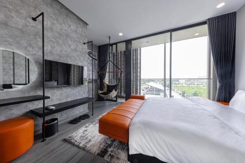a bedroom with a large bed and a large window at The Hammock Hotel Global City in Ho Chi Minh City