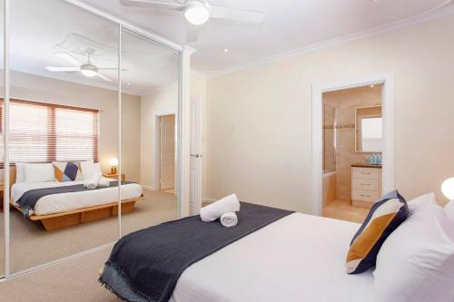 1 Schlafzimmer mit 2 Betten und einer Glaswand in der Unterkunft Directors Cottage Fabulous Local & Peaceful in Fremantle