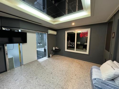 a living room with a flat screen tv and a couch at Songjeong Coco Hotel in Busan