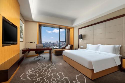 a hotel room with a large bed and a desk at Crowne Plaza Yichang by IHG in Yichang