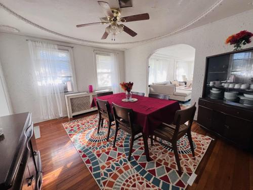 a dining room with a red table and chairs on a rug at Charming 3 Bedroom Cottage Apartment in a Tudor-Style Home in Pittsburgh