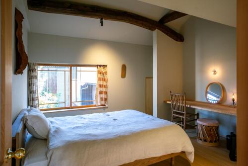 a bedroom with a large bed and a window at Une stay&diner in Sasayama