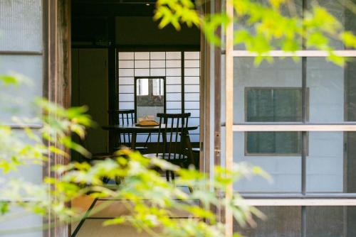 a porch with a table and chairs and a window at Une stay&diner in Sasayama