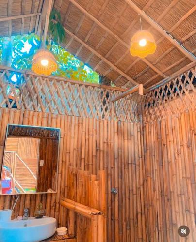 a wooden bathroom with a sink and a mirror at GAïA Cabinhouse in Cebu City