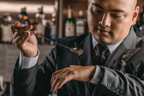 a man in a suit and tie holding a spoon at JW Marriott Hotel Hanoi in Hanoi