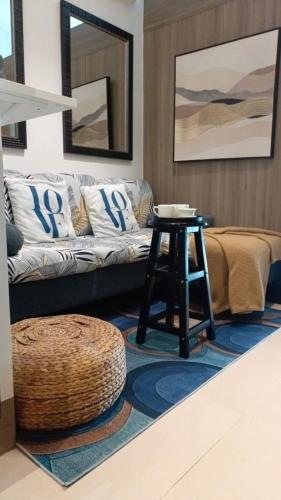 a living room with a couch and a table at Cozy New 1BR Fame Residences Condo with Balcony in Manila