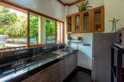 a kitchen with a sink and a refrigerator at Ocean Pearl Seaview Residence in Rawai Beach