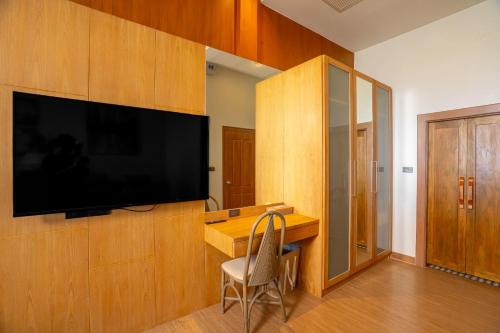 a room with a desk and a television on a wall at Ocean Pearl Seaview Residence in Rawai Beach