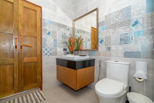 a bathroom with a toilet and a sink and a mirror at Ocean Pearl Seaview Residence in Rawai Beach